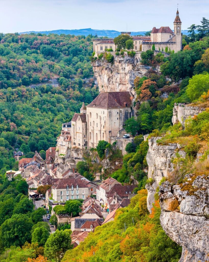 Rocamadour illuminated by daylight, with its cliffside houses and sanctuaries rising above the valley.
