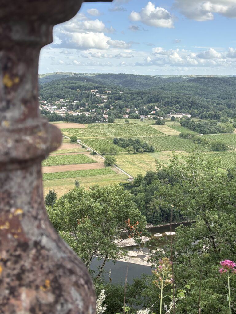Panoramic view of the Lot Valley in France with Cahors vineyards, the River Lot, a hilltop village and rolling green countryside